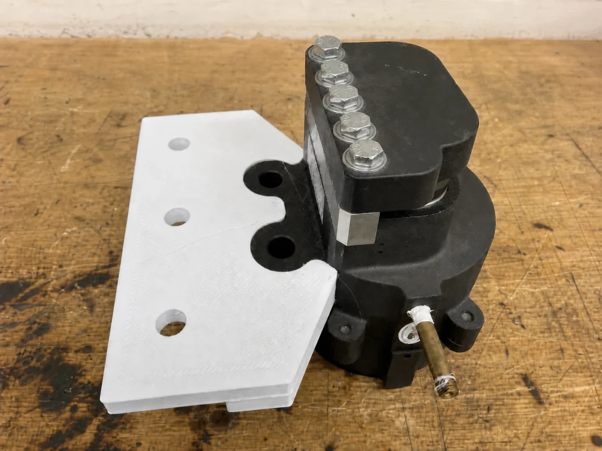 White full-scale printed mount positioned against the black pneumatic brake caliper